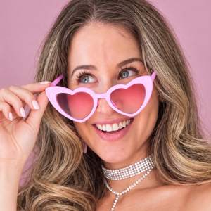 Natalie Smotkin in pink heart-shaped sunglasses, smiling